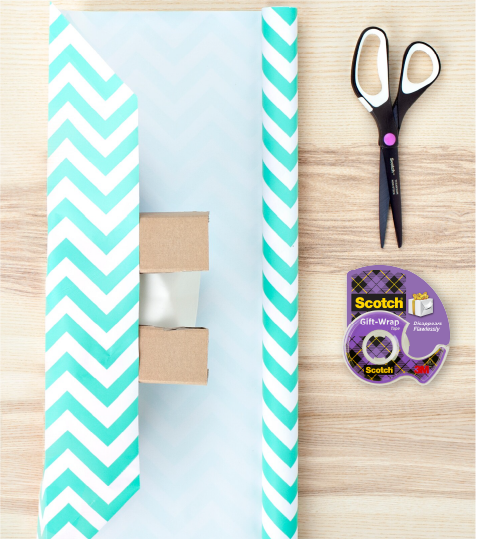 Envoltura de regalo recortada con diseño irregular y packshot Cinta Giftwrap Scotch®, para uso de producto Cinta de regalo Scotch.