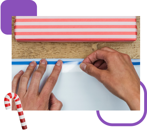 Manos de mujer pegando papel de regalo con Cinta de Regalo Scotch®.